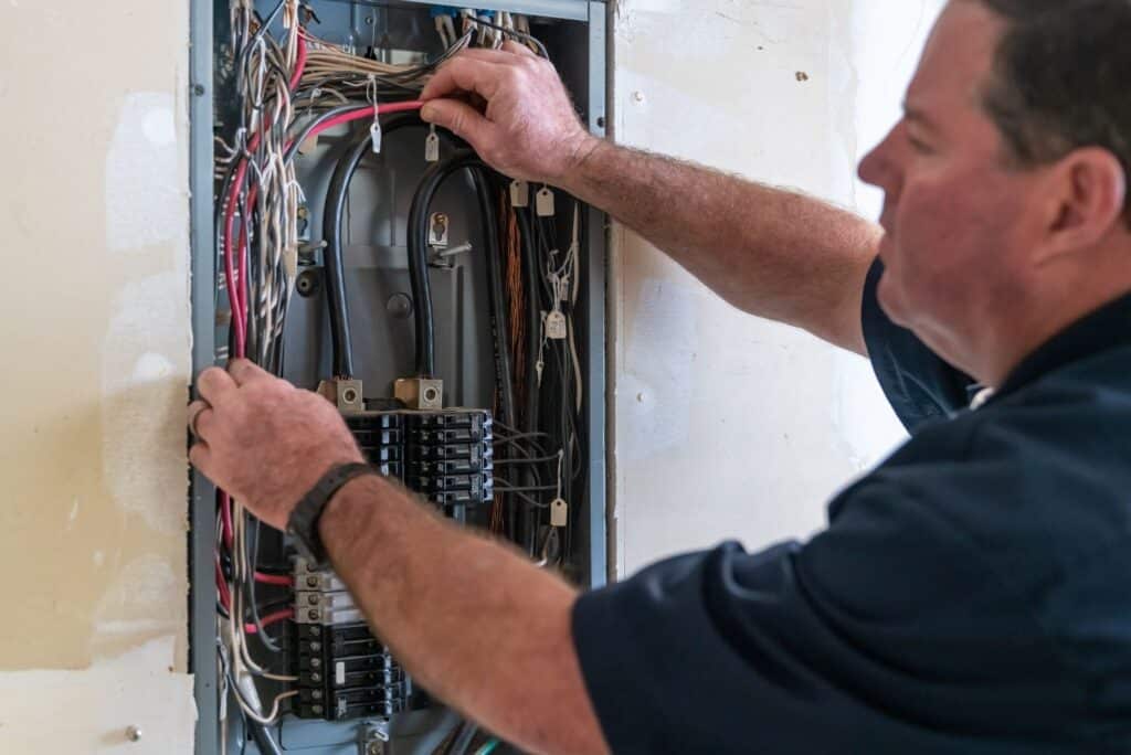 Electrician repairing circuit breaker panel