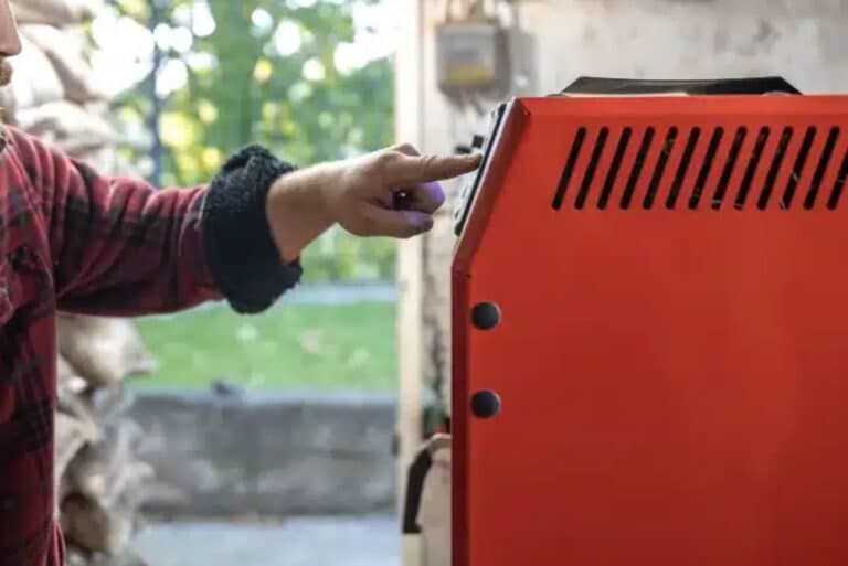 Person adjusting red heating unit control panel.