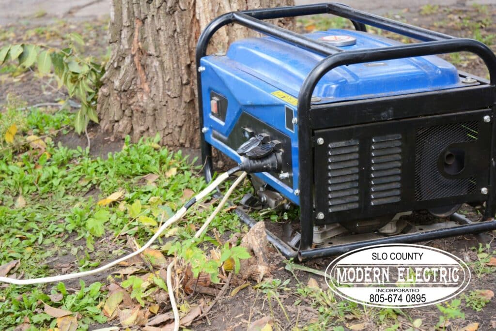 Portable gas generator outdoors near tree.