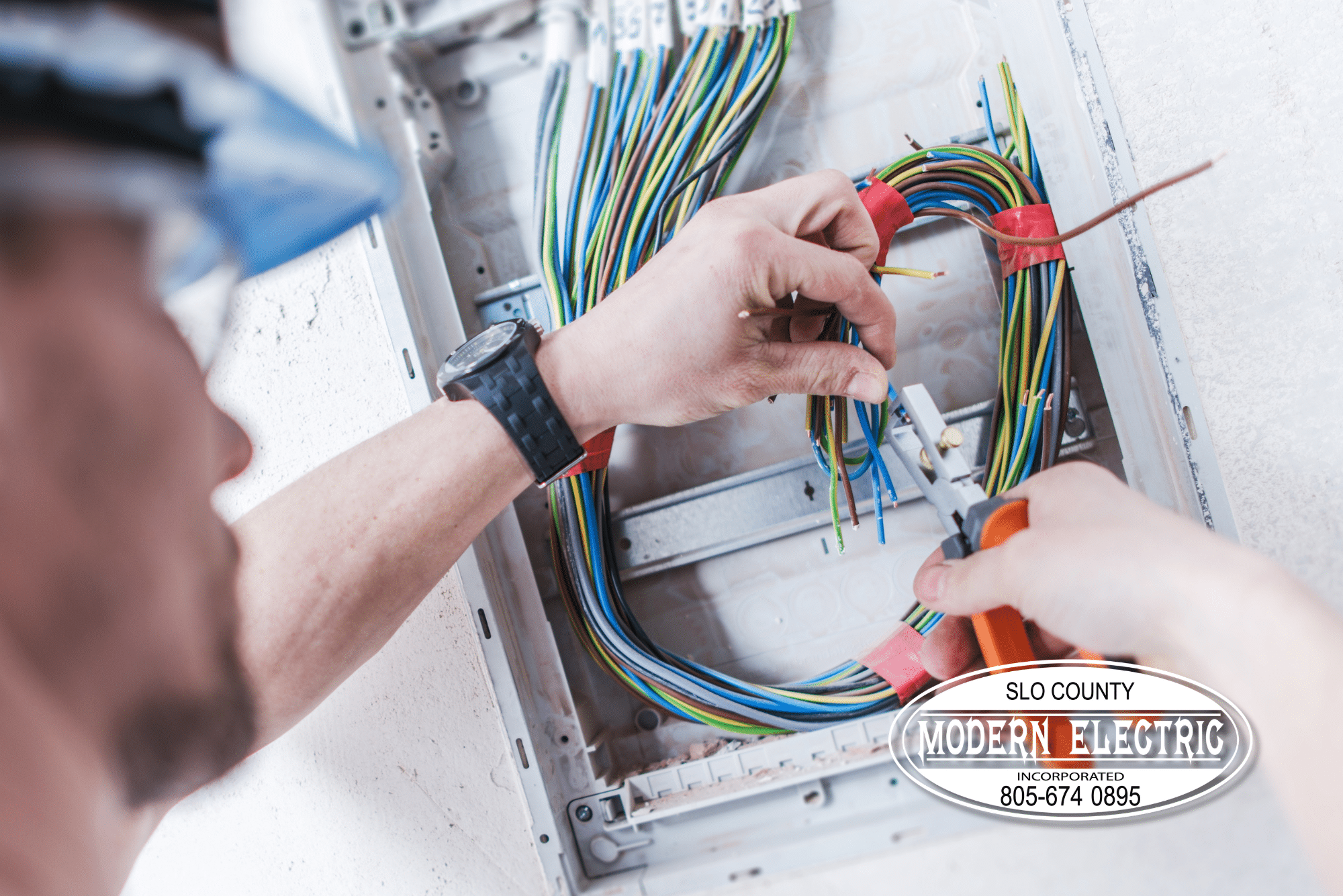Electrician working with wires in a panel.