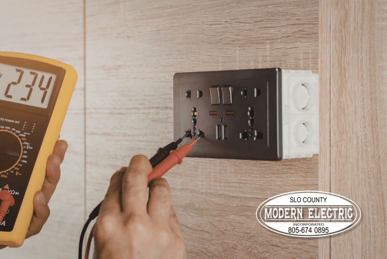 Electrician testing wall socket for voltage