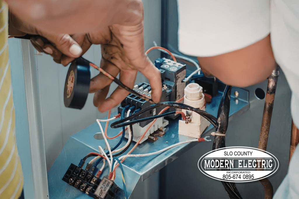 Hands repairing electrical panel system with tools.