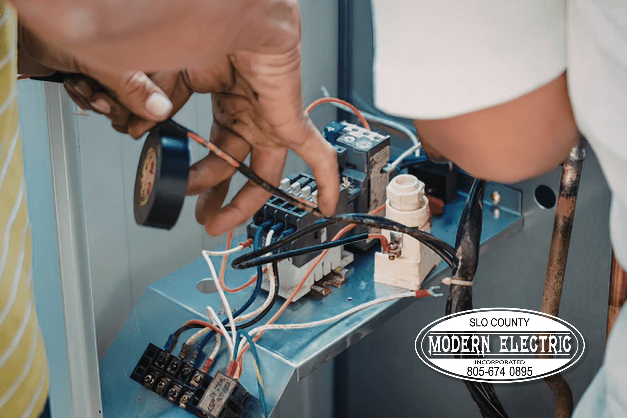 Hands repairing electrical panel system with tools.