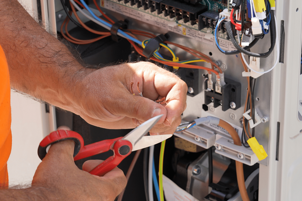 Technician fixing electrical wires with pliers